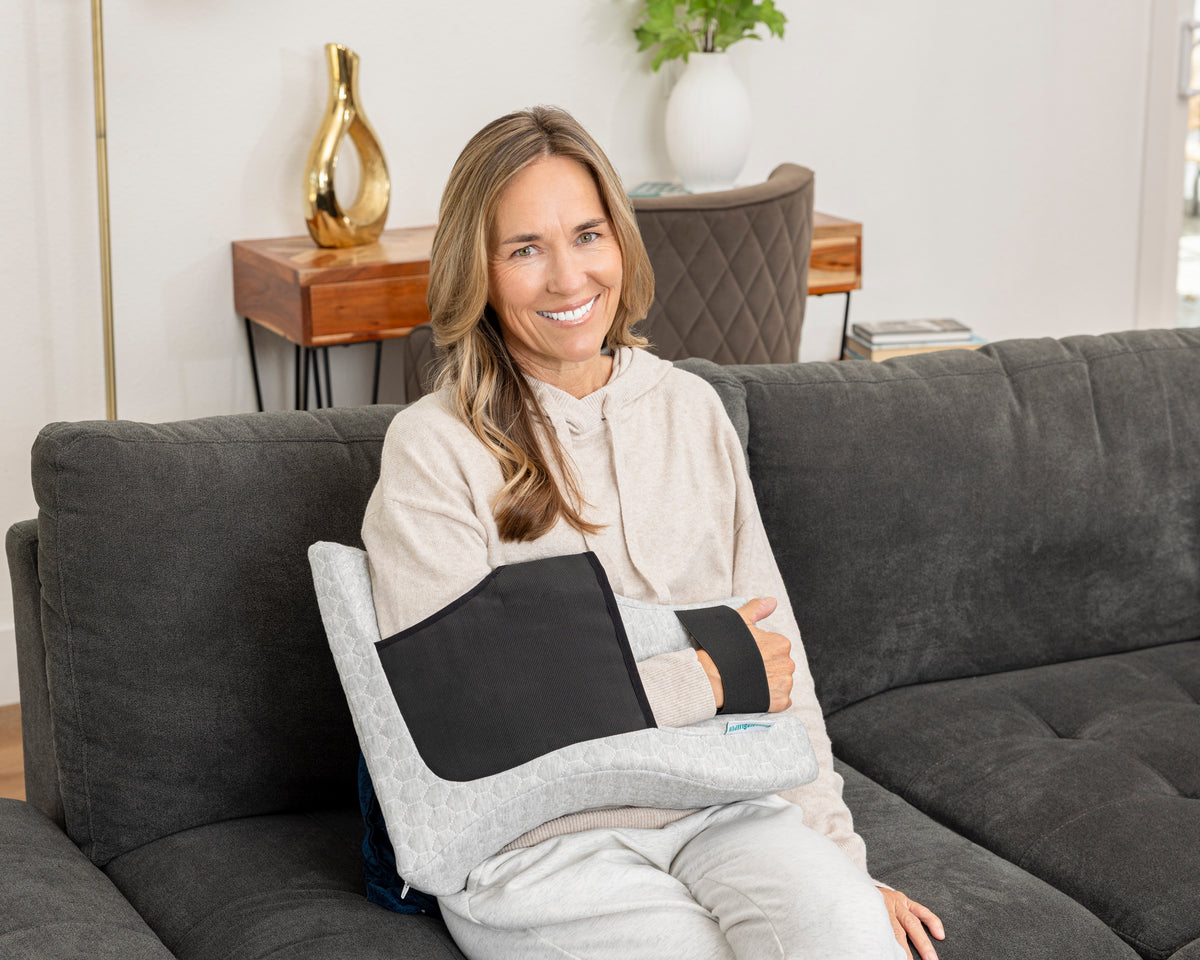 Woman resting with the Shoulder Sleeper Pillow positioning her arm